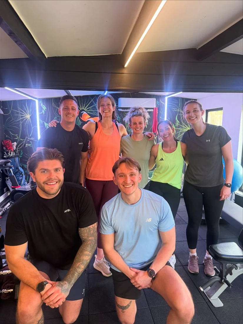 A small group of JungleFit members smiling in the studio
