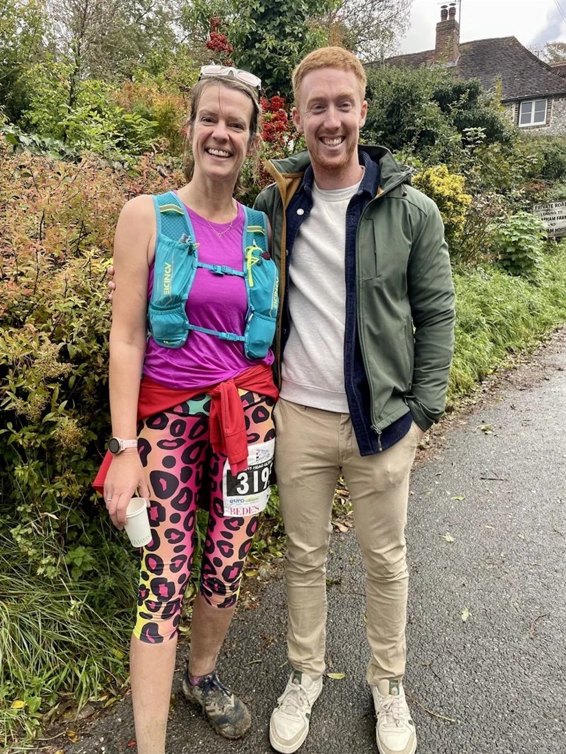 Two JungleFit members smiling after a race, one wearing a running vest and race number