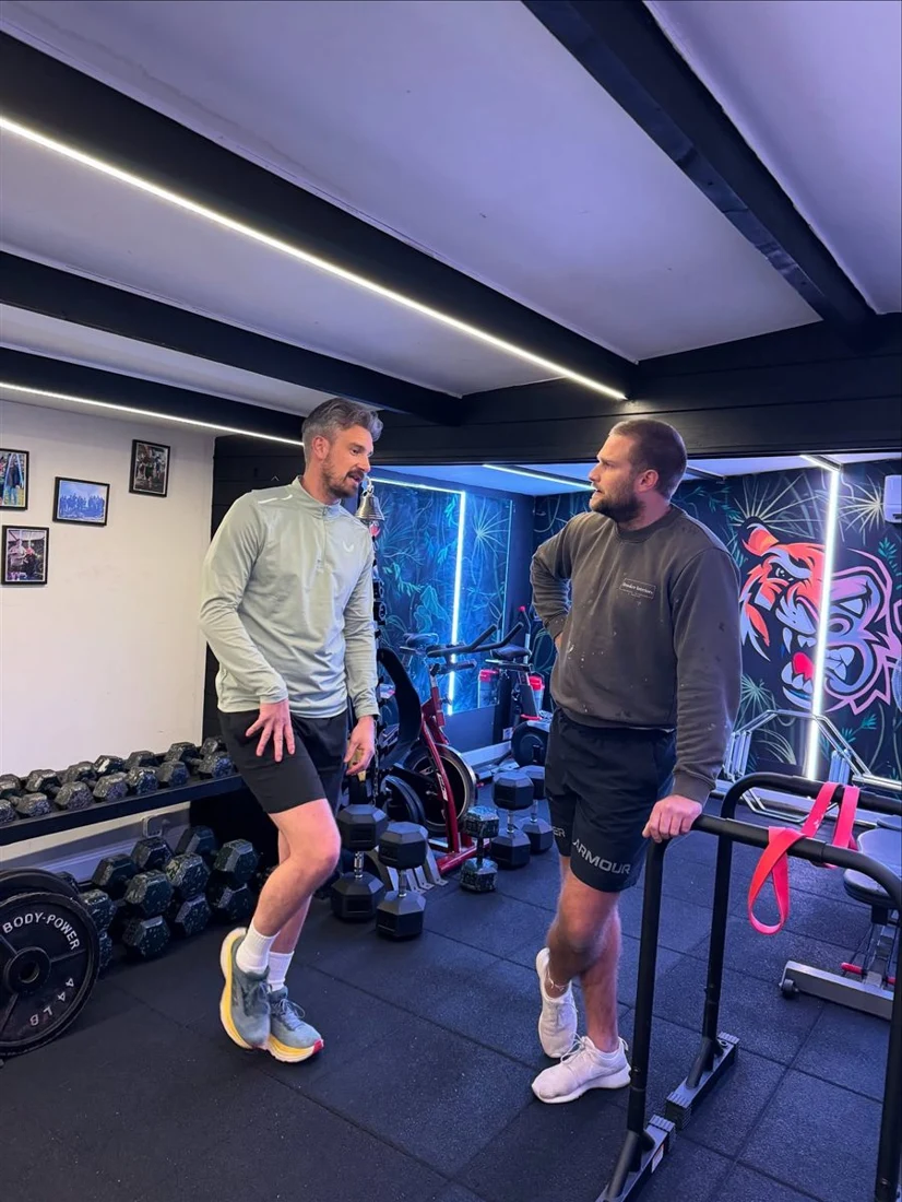 Two members training in the studio in front of the tiger mural